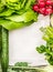 Salad vegetables ingredients around white wooden tray, top view