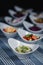 Salads in white plates on the table. Salad of cabbage, cucumber and apple in the foreground. In the blurry background