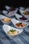 Salads in white plates on the table. Salad of Korean carrots, cucumber and cheese in the foreground. In the blurry