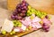 Salami, mortadella, cheese, yellow and red muscat grape on a wooden board and canvas
