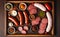 salami sausages, spices and meat products in a wooden tray, Free space for text,