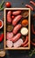 salami sausages, spices and meat products in a wooden tray, Free space for text,