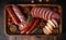 salami sausages, spices and meat products in a wooden tray, Free space for text,