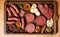 salami sausages, spices and meat products in a wooden tray, Free space for text,