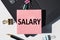 SALARY note is written on a paper sticker on a laptop keyboard