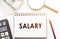 SALARY - text written on a notebook with office background