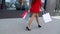 Sale, consumerism: Confident lady at heels with shopping bags walking after in a city. beautiful female legs.