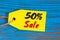 Sale minus 50 percent. Big sales fifty percents on blue wooden background for flyer, poster, shopping, sign, discount