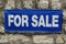 For sale plate on house