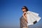 Sale: shopaholic girl holds shopping bags against blue sky