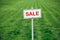 Sale sign against trimmed lawn background