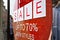 Sale up to seventy percent new styles sign - white letters in red circle - on glass window of clothes shop