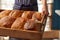 Sales Assistant In Bakery With Tray Of Freshly Baked Organic Sourdough Bread Loaves