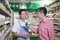 Sales clerk smiling and assisting man in supermarket, Beijing