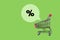 Sales and discounts concept, shopping cart and the percent icon above it on green background