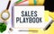 sales playbook on notepad with pen, glasses and calculator