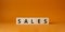 Sales symbol. Concept word Sales on wooden cubes. Beautiful orange background. Business and Sales concept. Copy space