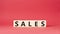 Sales symbol. Concept word Sales on wooden cubes. Beautiful red background. Business and Sales concept. Copy space