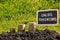 Sales training. Financial opportunity concept. Golden coins in soil Chalkboard on blurred urban background.