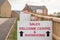 Sales welcome centre and showhome sign on new residential homes development estate entrance in England