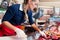 Sales woman in butcher shop putting different kinds of meat in display