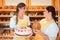 Sales women in bakery with cake and bread