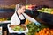 Salesgirl arranging goods in greengrocery