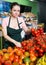 Salesgirl arranging vegetables on shop shelves