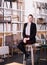 Salesgirl sitting on chair in furniture shop