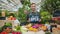 Salesman in apron holding open sign in organic food market welcoming people