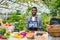 Salesman in apron holding open sign in organic food market welcoming people