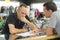 Salesman asking man to sign receipt in store