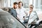 Salesman with couple in the car showroom