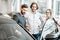 Salesman with couple in the car showroom