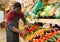 Salesman filling counter with vegetables and fruits