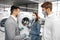 Salesman in hypermarket wearing medical mask demonstrates his clients a new washing machine