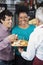 Salesman Offering Cheese Samples To Happy Customers In Shop