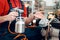 Salesman is posing with compressor paint sprayer on foreground in power tools store.