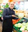 Salesman posing near different vegetables
