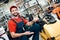 Salesman is posing with plate compactor on foreground in power tools store.