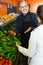 Salesman serving buyer purchasing veggies