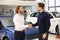 Salesman shaking hands with client in dealership