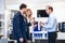 Salesman Showing Espresso Cups To Couple In Hypermarket