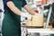 Salesman Slicing Cheese With Double Handled Knife