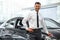 Salesman Stands Near Brand New Car. Car Showroom