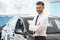 Salesman Stands Near Brand New Car. Car Showroom