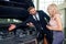 Salesman in suit showing catalog to female blonde customer in dealership salon