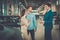 Salesman talking to a young couple at the dealership showroom.