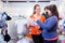 Salesperson with couple buying baby clothes in shop