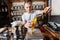 Salesperson scooping ingredient into paper bag at tea store